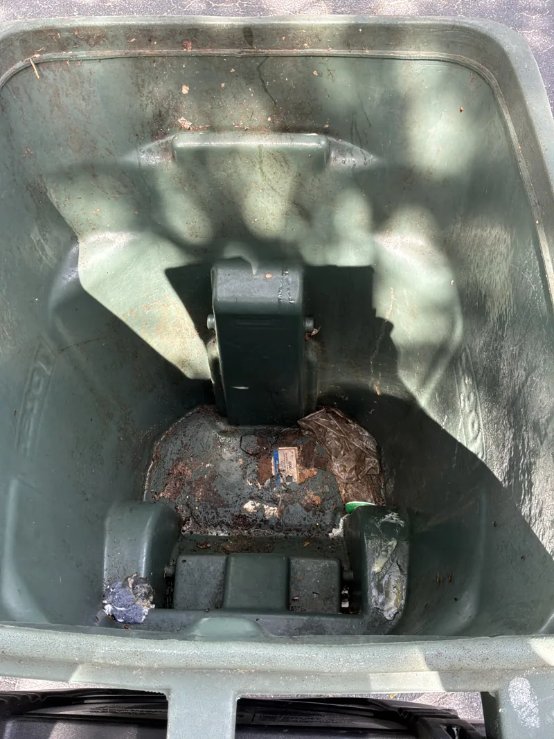 The green bin before cleaning, with waste residue at the bottom